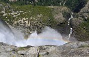 Leaning over the edge of the rail looking down at the rainbow at the base of the falls. Where the stream disappears at top is where Lower Yosemite Falls begins.