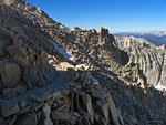 2 hikers (top left) on the west side of the Mt. Whitney trail through boulders and rubble 