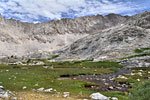 At the edge of treeline is a final lush meadow basin before tackling the long ascent to Forester Pass. The trail climbs the valley between the two mountains.