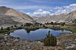 A pair of hikers cool off at the meadow's lake, hidden from the trail behind a stony bluff