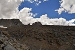 A backpacker silhouetted against a swarm of fast-moving clouds
