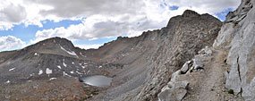 The other/south side of Forester Pass. Stone embankments support the steep switchbacked trail below the pass (top right).
