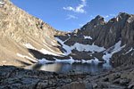 A pair of hikers (bottom center) at Consultation Lake near Trail Camp.