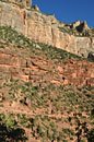 A group of a dozen backpackers (bottom center) slowly trudge up the trail beneath the soaring South Rim cliffs.