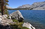 Bench is a large beauty of a lake where the fish are jumping.