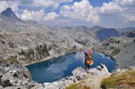 A fellow hiker admiring Iceberg Lake after a tough climb up the wall of scree