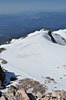 The big summit snowfield tapers down to the pinnacle of Misery Hill, where you can see climbers silhouetted.