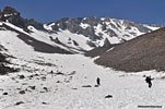 Some try more glissading (center left) on the way out, but its hot now and the snow has already melted enough to make it more of an exertion than walking